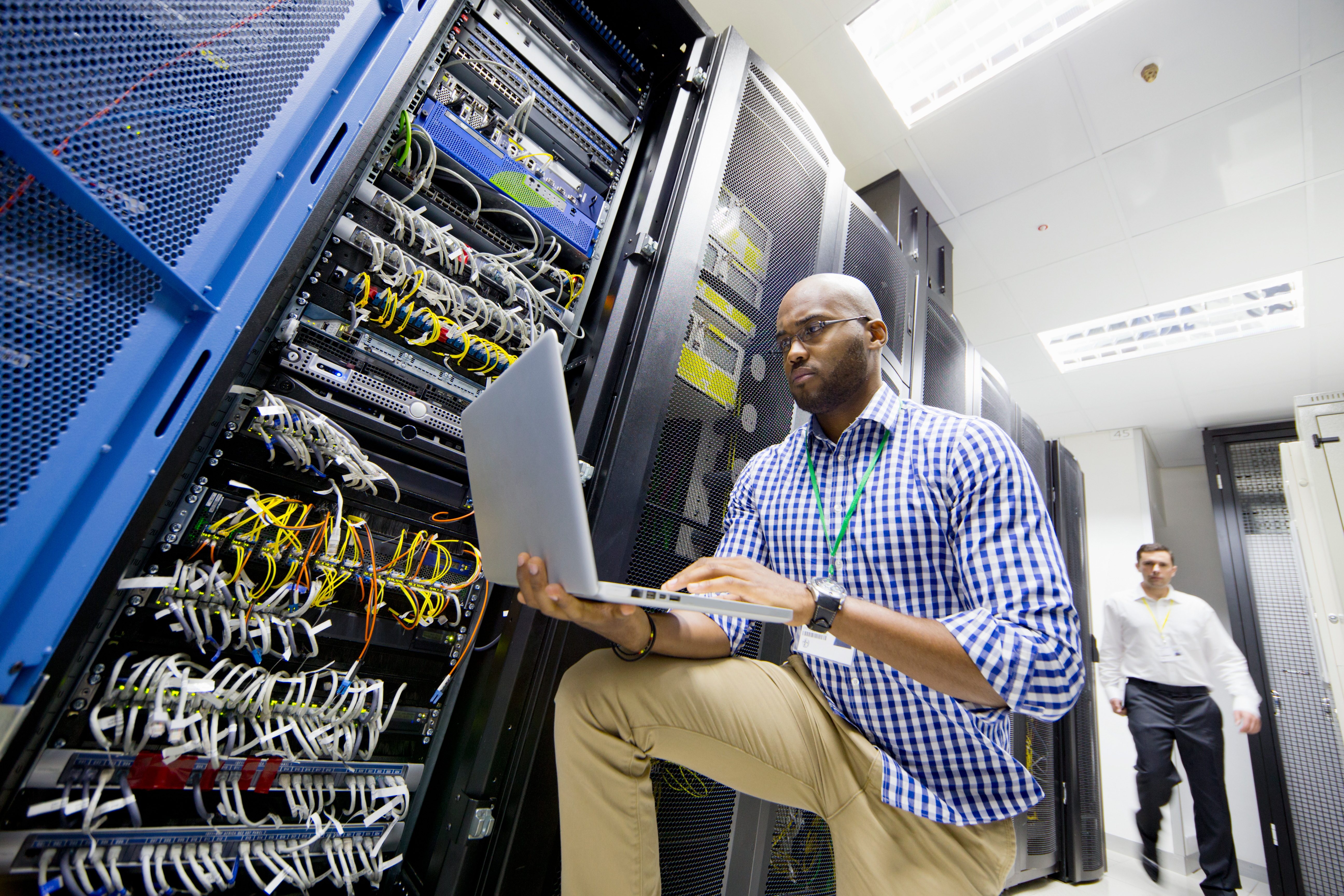 Technician working with laptop in data center